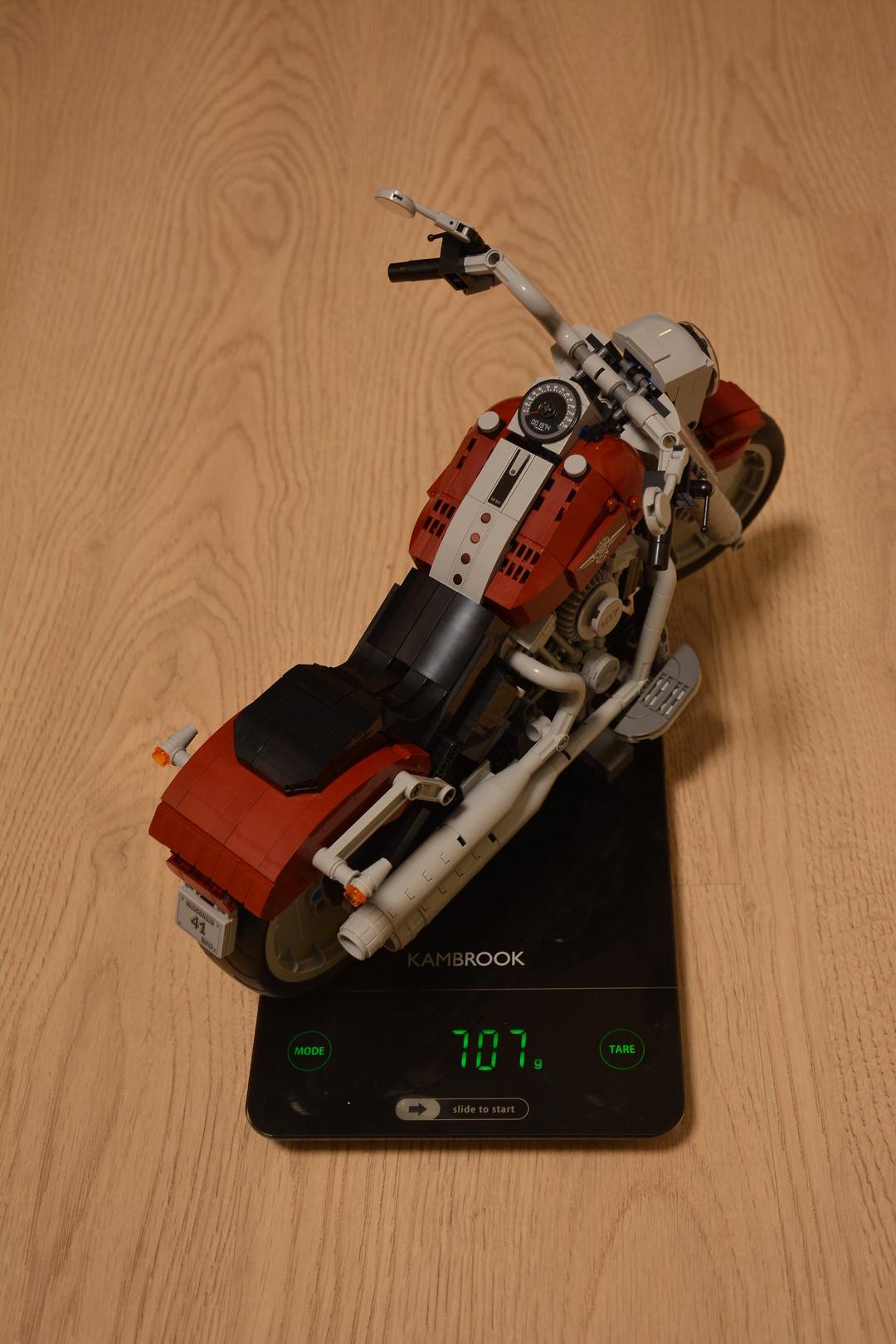 Модель на кухонных весах, показывающих 707 грамм